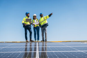 Team of engineers inspecting rooftop solar panels for PV fire-safety compliance during maintenance.